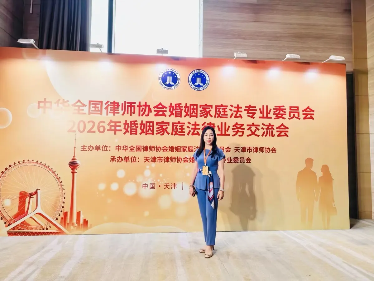 June Zhang in front of the backdrop of the marriage and family law practice exchange in Tianjin